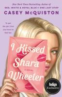 The cover of I Kissed Shara Wheeler. A blonde girl with blue eyes and pale skin holds a pink, kiss-marked envelope in front of her face. 